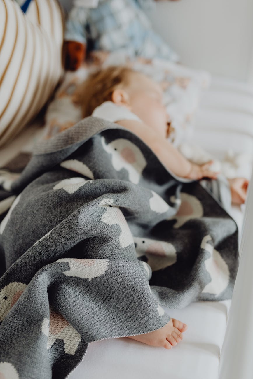 shallow focus photo of a cozy blanket wrapped around a sleeping baby