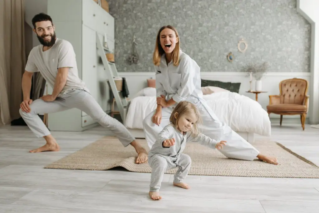 a couple stretching their legs while looking at their cute daughter