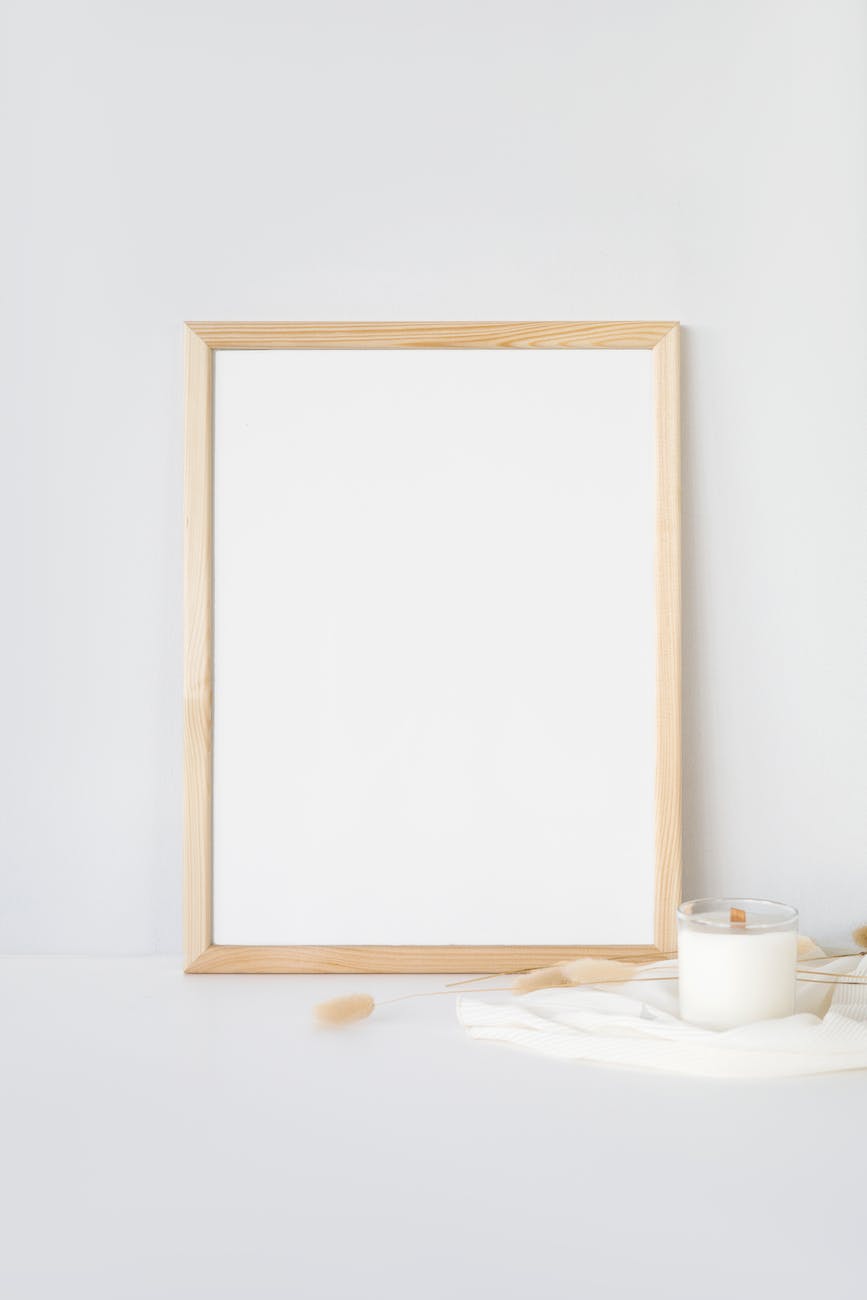 a blank whiteboard with wooden frame on a white wall