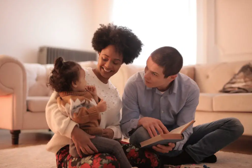 photo of man and woman having fun with their baby